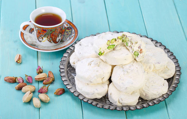 گز پسته ای اصفهانی در کنار یک فنجان چای